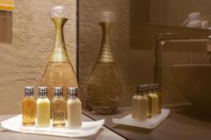 um grupo de garrafas de óleo em um balcão ao lado de dois vasos em Palazzo Marletta Luxury House Hotel em Catânia