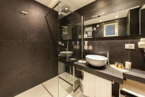 bagno nero con lavandino e specchio di Palazzo Marletta Luxury House Hotel a Catania