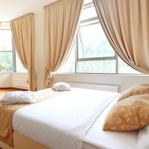 a bed in a bedroom with a large window at SkyPoint Hotel Sheremetyevo Airport in Khimki