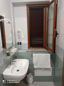 uma casa de banho com um lavatório e um espelho em AFFITTACAMERE BORGATA MARINA em Roseto Capo Spulico
