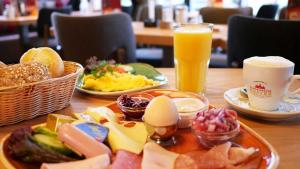 stół z talerzami jedzenia i szklanką soku pomarańczowego w obiekcie Gasthof Bad Hopfenberg w mieście Petershagen