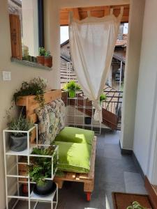 balcone con divano verde e piante in vaso di Guest House Seme Di Faggio a Miasino
