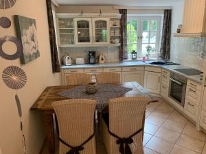 a kitchen with a wooden table and chairs at Villa Friedericia - Appartment 1 in Wyk auf Föhr