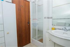a bathroom with a sink and a glass shower at Apartamento Quarteira Praia in Quarteira +16 photos