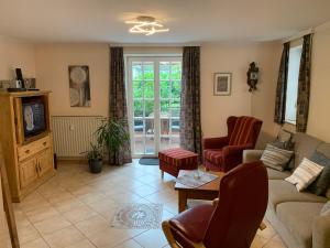 a living room with a couch and a tv at Villa Friedericia - Appartment 1 in Wyk auf Föhr