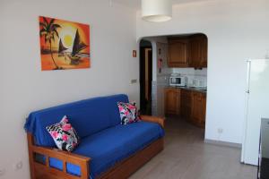 un divano blu in soggiorno con cucina di Apartamento Quarteira Praia a Quarteira