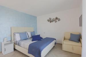 ein Schlafzimmer mit einem Bett und einem Stuhl in der Unterkunft SeaView Sorrento Apartment by the sea with terrace in Sorrent