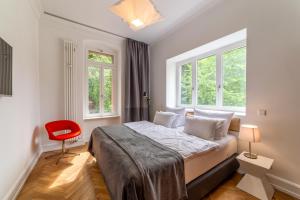 a bedroom with a bed and a red chair at Zweite Heimat Heidelberg in Heidelberg