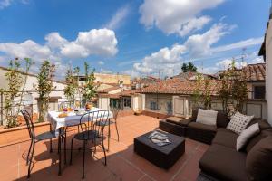 a patio with a couch and a table on a balcony at Attic Up On Florence in Florence