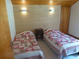 2 łóżka w pokoju z drewnianymi ścianami w obiekcie Le Fayet d'en haut w mieście Abondance