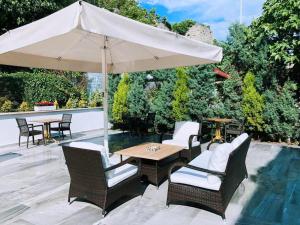 a patio with a table and chairs and an umbrella at Sardinia Otel in Amasra