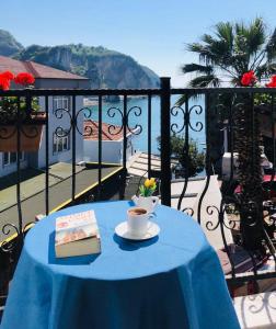 uma mesa com um livro e uma chávena de café na varanda em Sardinia Otel em Amasra