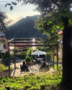 a group of people sitting in chairs under a pergola at Apartament Leśny - Leśna 30 in Kudowa-Zdrój