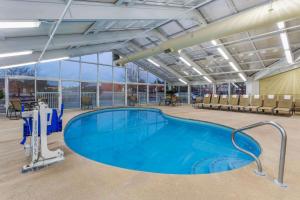 a large swimming pool in a large building with chairs at La Quinta by Wyndham Rockford in Rockford