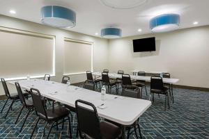 a conference room with tables and chairs and a tv at La Quinta by Wyndham Lake Charles - Westlake in Westlake