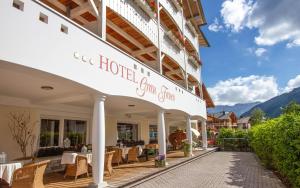 Hotel Gran Fanes في كورفارا إنْ بادِيا: فندق به طاولات وكراسي على فناء