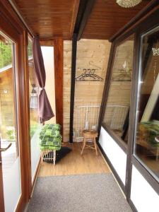 eine abgeschirmte Veranda mit einem Stuhl und Fenstern in der Unterkunft Auf die 12 - Auf die 13 in Freyung