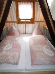 a small room with two beds and a window at Auf die 12 - Auf die 13 in Freyung