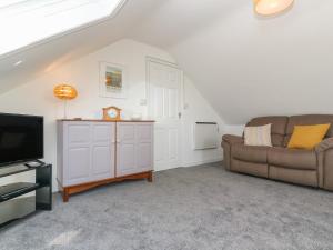 a living room with a couch and a tv at Little Valley View in Hayle