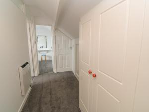 an empty hallway with a white door and a room at Little Valley View in Hayle