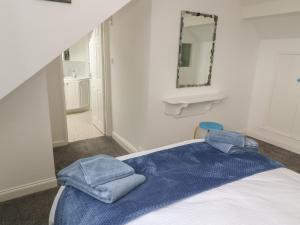 a bedroom with a bed with blue towels on it at Little Valley View in Hayle