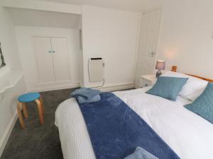 a bedroom with a bed with a blue blanket on it at Little Valley View in Hayle