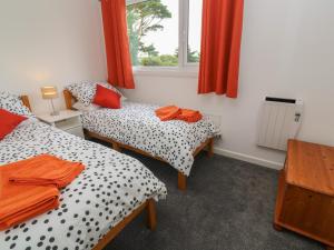 two twin beds in a room with a window at Little Valley View in Hayle