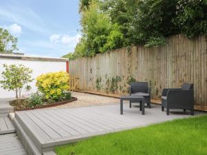 a backyard with two chairs and a wooden fence at Little Valley View in Hayle
