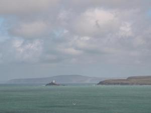 a lighthouse on an island in the middle of the ocean at Little Valley View in Hayle