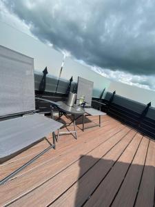 een terras met een tafel en stoelen op een boot bij Romneys Apartments & Suites in Kendal