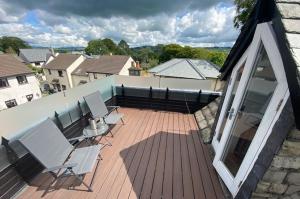 eine Terrasse mit 2 Stühlen und einem Tisch auf einem Haus in der Unterkunft Romneys Apartments & Suites in Kendal