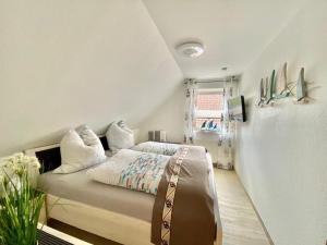 - une chambre avec un lit dans une pièce dotée d'une fenêtre dans l'établissement Ferienhaus Antje Greetsiel Nordsee, à Krummhörn