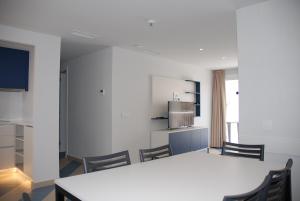 kuchnia ze stołem i krzesłami w pokoju w obiekcie Apartamentos Sunway Arizona w mieście Sitges