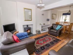 ein Wohnzimmer mit Couch und Kamin in der Unterkunft Victoria Cottage in Chipping Norton