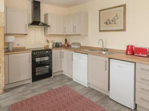 a kitchen with white cabinets and a sink at The Folly in Newcastle upon Tyne