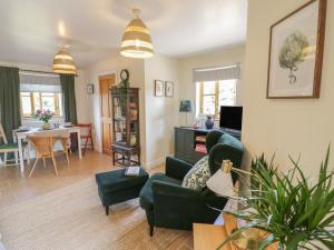 a living room with a couch and chairs and a table at Holmer Farm in Leominster