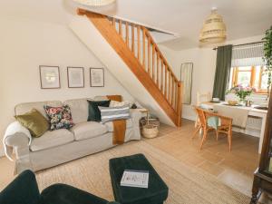 a living room with a couch and a staircase at Holmer Farm in Leominster