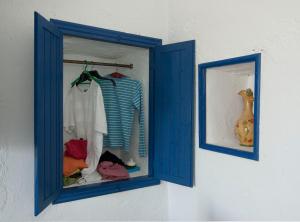 a blue window with clothes in it on a wall at Alisideri Studios in Karavostasi
