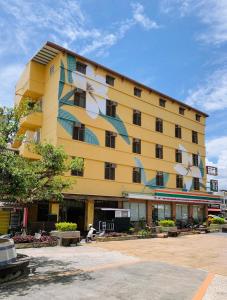 a yellow building with a painting on the side of it at Heng-zhan Inn in Hengchun