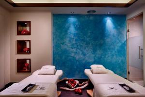 two beds in a room with a blue wall at Rodos Park in Rhodes Town