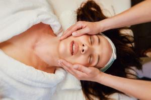 a woman getting her face groomed by a massage therapist at Rodos Park in Rhodes Town