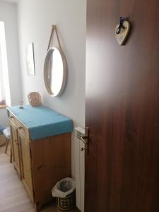 een badkamer met een spiegel en een deur met een tafel bij B&b Zita in Levico Terme
