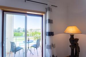 a sliding glass door leading to a patio with a table and chairs at T2 Branquinho in Nazaré