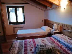 a bedroom with two beds and a window at La Maison Du Bon Megnadzo in Doues