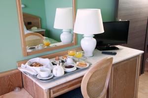 een dienblad met eten op een tafel in een hotelkamer bij Hotel Europa in Ispra
