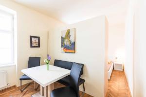 a white dining room with a white table and chairs at Ferienwohnung Klangturm im Zentrum in Sankt Pölten