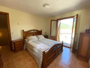 1 dormitorio con cama grande y ventana grande en CASA PEDRO BERGUA, en Fiscal