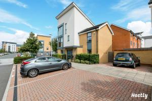 two cars parked in a parking lot in front of a house at Elephant Court - Comfortable, spacious house with parking in Reading