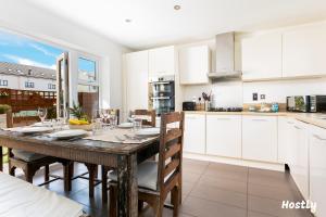 a kitchen and dining room with a wooden table and chairs at Elephant Court - Comfortable, spacious house with parking in Reading