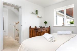 a white bedroom with a bed and a window at Elephant Court - Comfortable, spacious house with parking in Reading +17 photos